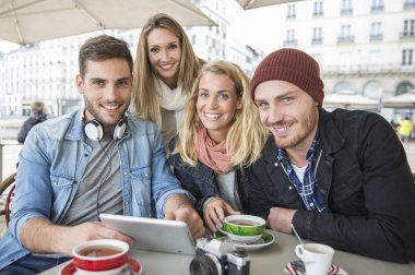 in arkadaş grubu ile dijital tablet vasıl seyir kahve dükkanı
