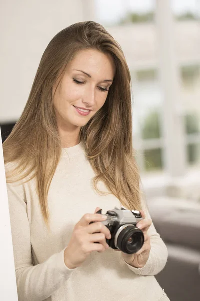 Красива весела дівчина використовує старовинну фотокамеру — стокове фото