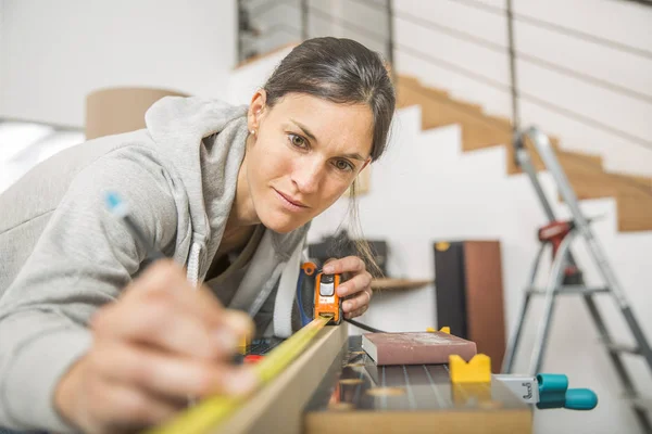 Single young woman standing by workbench at home — Stock Photo, Image