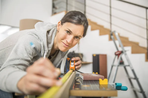 Single young woman standing by workbench at home — Stock Photo, Image