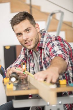 Ev geliştirme için ahşap plakalar üzerinde çalışan adam