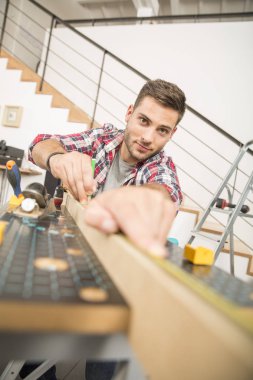 Ev geliştirme için ahşap plakalar üzerinde çalışan adam