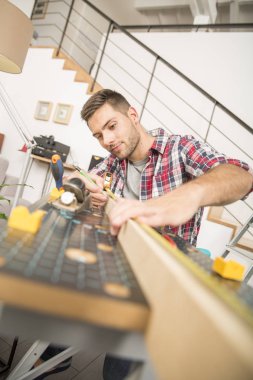 Ev geliştirme için ahşap plakalar üzerinde çalışan adam