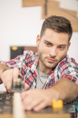 Ev geliştirme için ahşap plakalar üzerinde çalışan adam