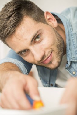Genç adam evde mobilya parçaları montaj