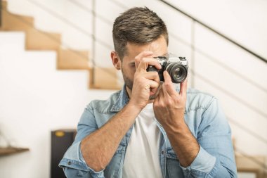 Adam evde vintage refleks kamera kullanarak