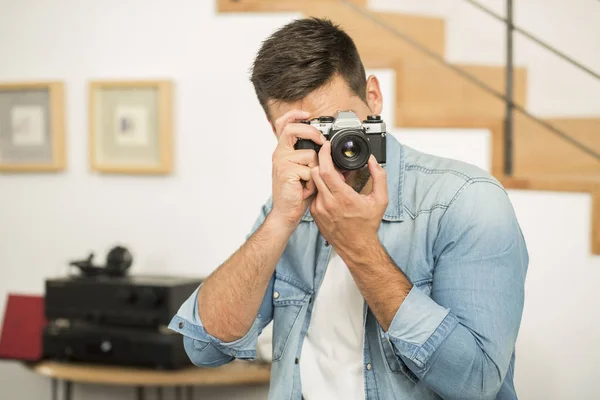 Людина вдома використовує вінтажну рефлекторну камеру — стокове фото
