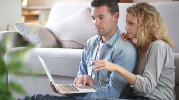 Feliz jovem casal assistindo internet em seu laptop — Vídeo de Stock