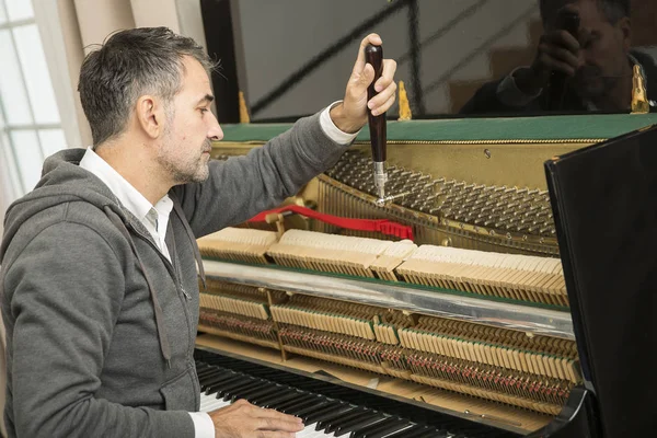 Técnico de piano reparando el piano —  Fotos de Stock