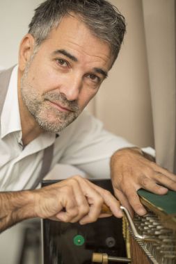 Teknisyen bir dik piyano kolu ve araçlarını kullanarak ayarlama