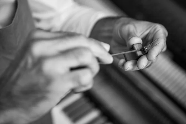Técnico afinando un piano vertical usando palanca y herramientas —  Fotos de Stock