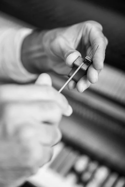 Técnico afinando un piano vertical usando palanca y herramientas —  Fotos de Stock