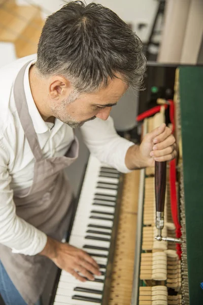 Técnico afinando un piano vertical usando palanca y herramientas —  Fotos de Stock