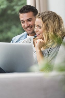 Onların dizüstü bilgisayarda İnternet izlerken mutlu genç Çift