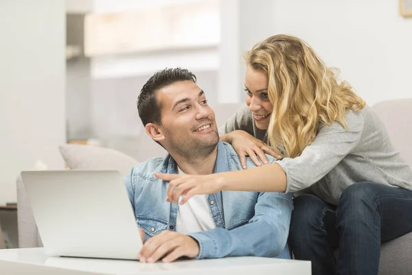 Feliz joven pareja viendo internet en su lapto — Foto de Stock