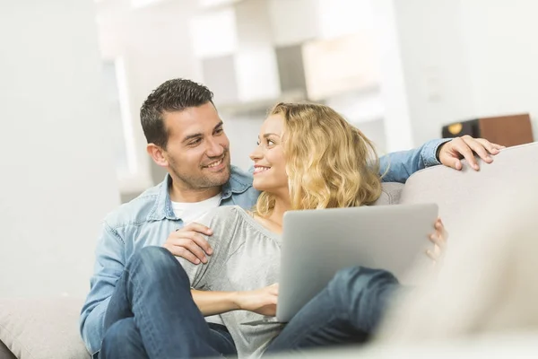 Happy young couple watching internet on their laptop — Stock Photo, Image