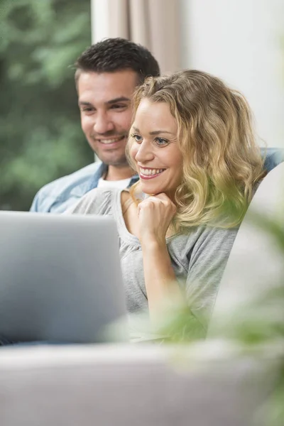 Feliz pareja joven viendo internet en su computadora portátil —  Fotos de Stock