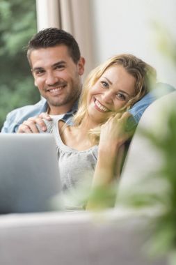 Onların dizüstü bilgisayarda İnternet izlerken mutlu genç Çift