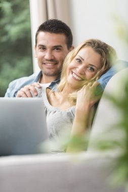 Onların dizüstü bilgisayarda İnternet izlerken mutlu genç Çift