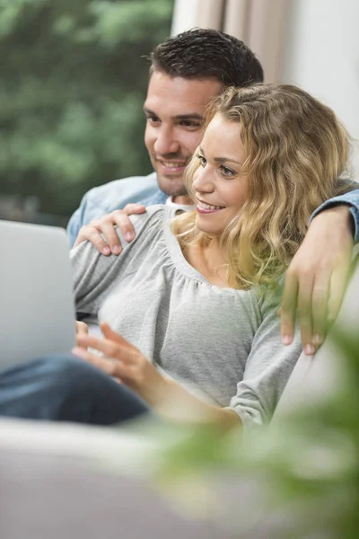 Feliz jovem casal assistindo internet em seu laptop — Fotografia de Stock