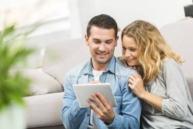 Onların oturma odasında bir tablet kullanarak rahat genç Çift