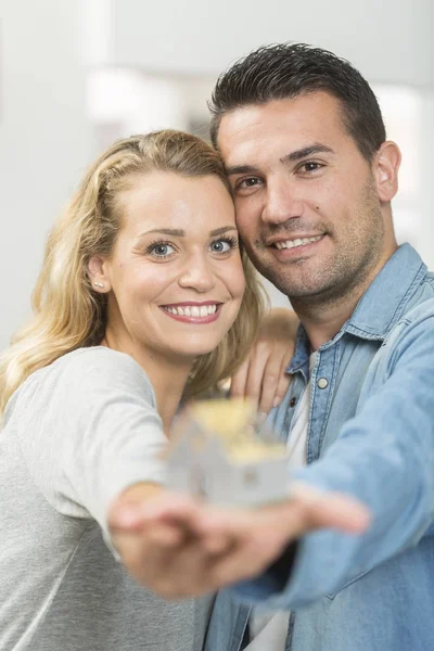 Jovem casal feliz com o modelo de sua futura casa — Fotografia de Stock