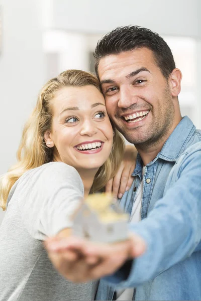 Happy νεαρό ζευγάρι με το μοντέλο του σπιτιού τους μελλοντικούς — Φωτογραφία Αρχείου