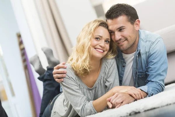 Pasangan muda yang bahagia yang ditemukan di karpet ruang tamu mereka — Stok Foto