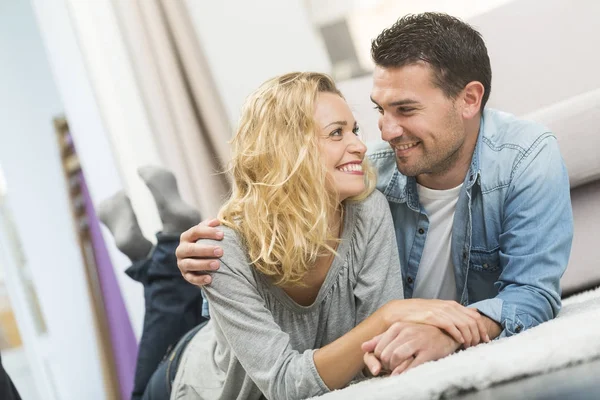 Happy young couple layed on the carpet of their living room — Stock Photo, Image