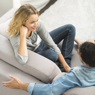 Kendi oturma odasında kanepede mutlu genç Çift