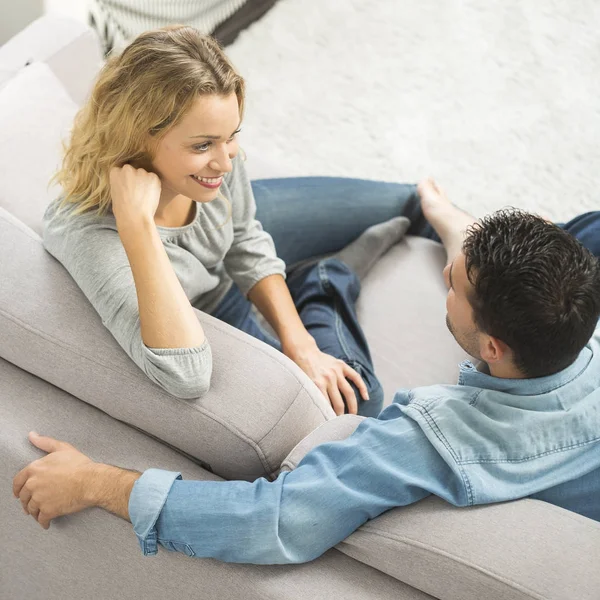 Happy young couple on the sofa of their living room — Stock Photo, Image