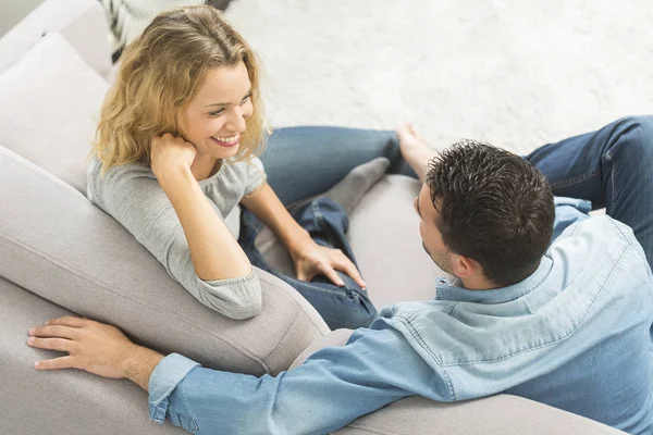 Happy young couple on the sofa of their living room — Stock Photo, Image