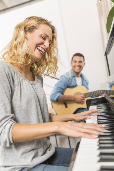 Young piano player accompanied by a guitarist