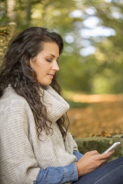 Güz sezonunda Smartphone kullanan kadın