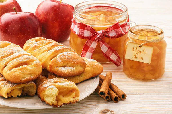 Свежие дрожжевые булочки с яблочным джемом и корицей на белом деревянном фоне . — стоковое фото