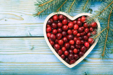 Kızılcık mavi ahşap arka plan üzerinde beyaz tepsi.