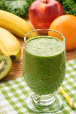 Sağlıklı taze smoothies ile meyve ve yeşil lahana yaprakları üzerinde ahşap arka plan.