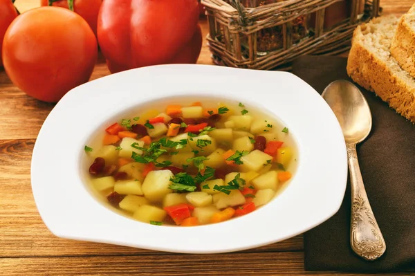 Transparent vegetarian soup with bean and vegetables. — Stock Photo, Image