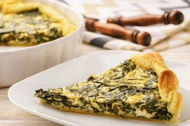 Ispanak ve beyaz arka plan üzerinde yumurta ile tart.