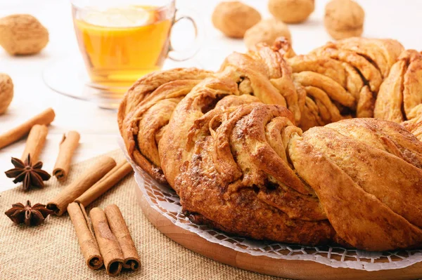 Braided cinnamon roll cake on wooden background. — Stock Photo, Image