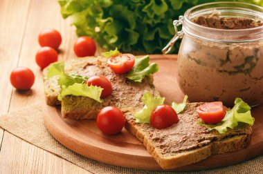 Ahşap tepsi üzerinde ekmek arası tavuk karaciğer pate.