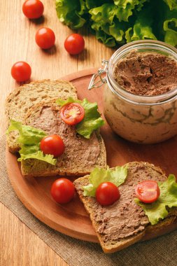 Ahşap tepsi üzerinde ekmek arası tavuk karaciğer pate.