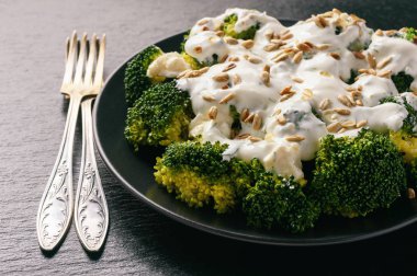 Brokoli Salatası beyaz peynir, sarımsak sosu ve ayçiçeği tohumu.