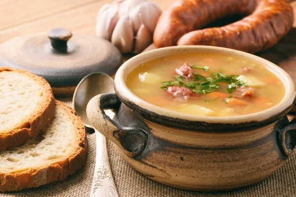 Гороховый суп с копченой колбасой на коричневом фоне . — стоковое фото