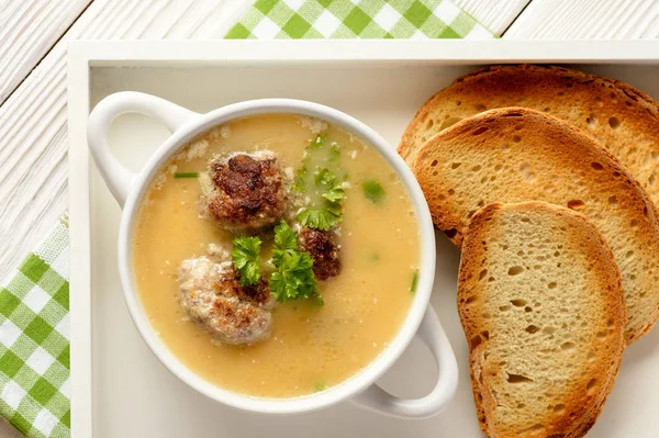 Суп из растительных сливок с фрикадельками на белом деревянном фоне . — стоковое фото