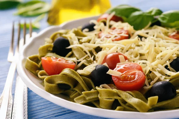 Pasta verde spinaci con olive, pomodori e formaggio . — Foto Stock