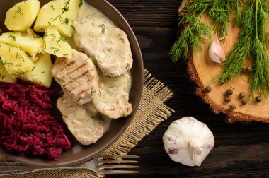 Dereotu patates ve pancar salatası ile servis ile ekşi krema soslu domuz eti bonfile ızgara.