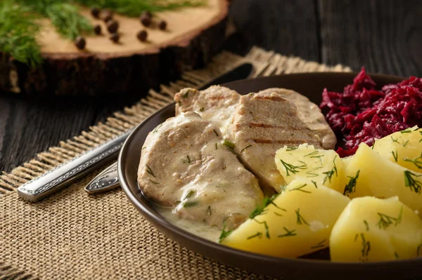 Grilled pork tenderloin in sour cream sauce with dill served with potatoes and beetroot salad. — Stock Photo, Image