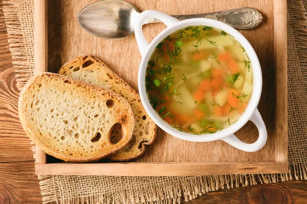 Sopa de pollo en tazón blanco en bandeja de madera . —  Fotos de Stock