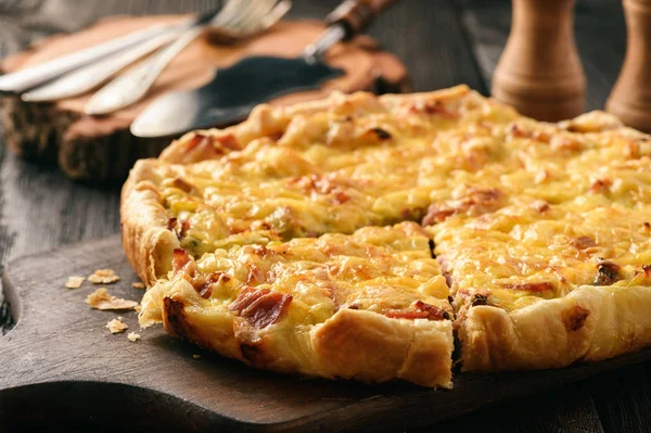 Quiche casero con puerro, jamón y queso sobre fondo de madera . — Foto de Stock